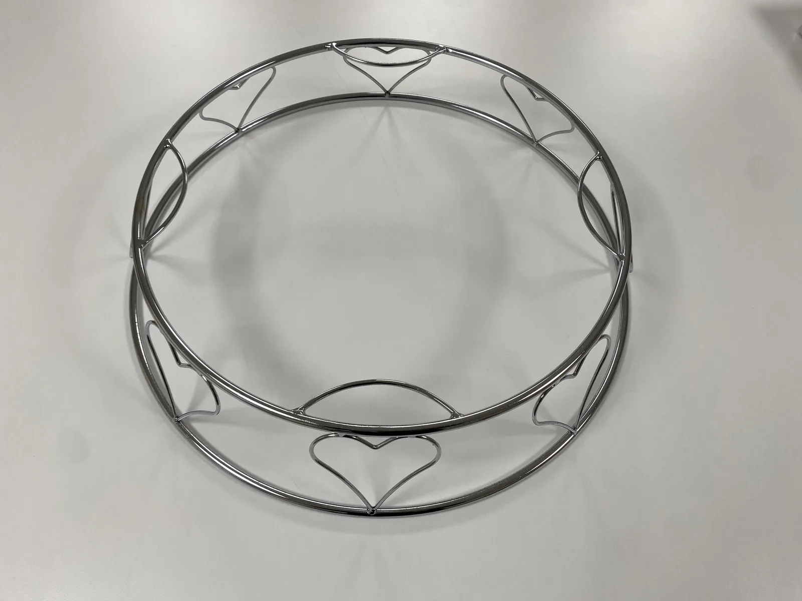 Round silver metal feature stand with heart details