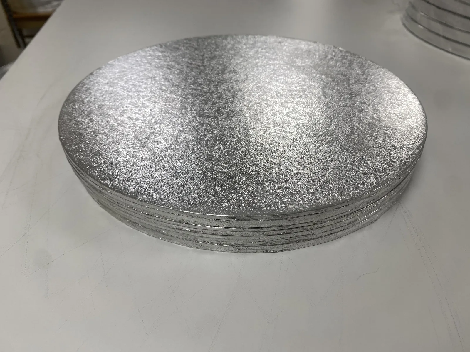 Stack of round 11-inch double-thick silver cake boards