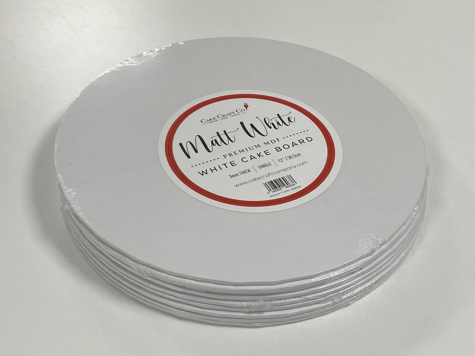 Four round white 12-inch MDF cake boards