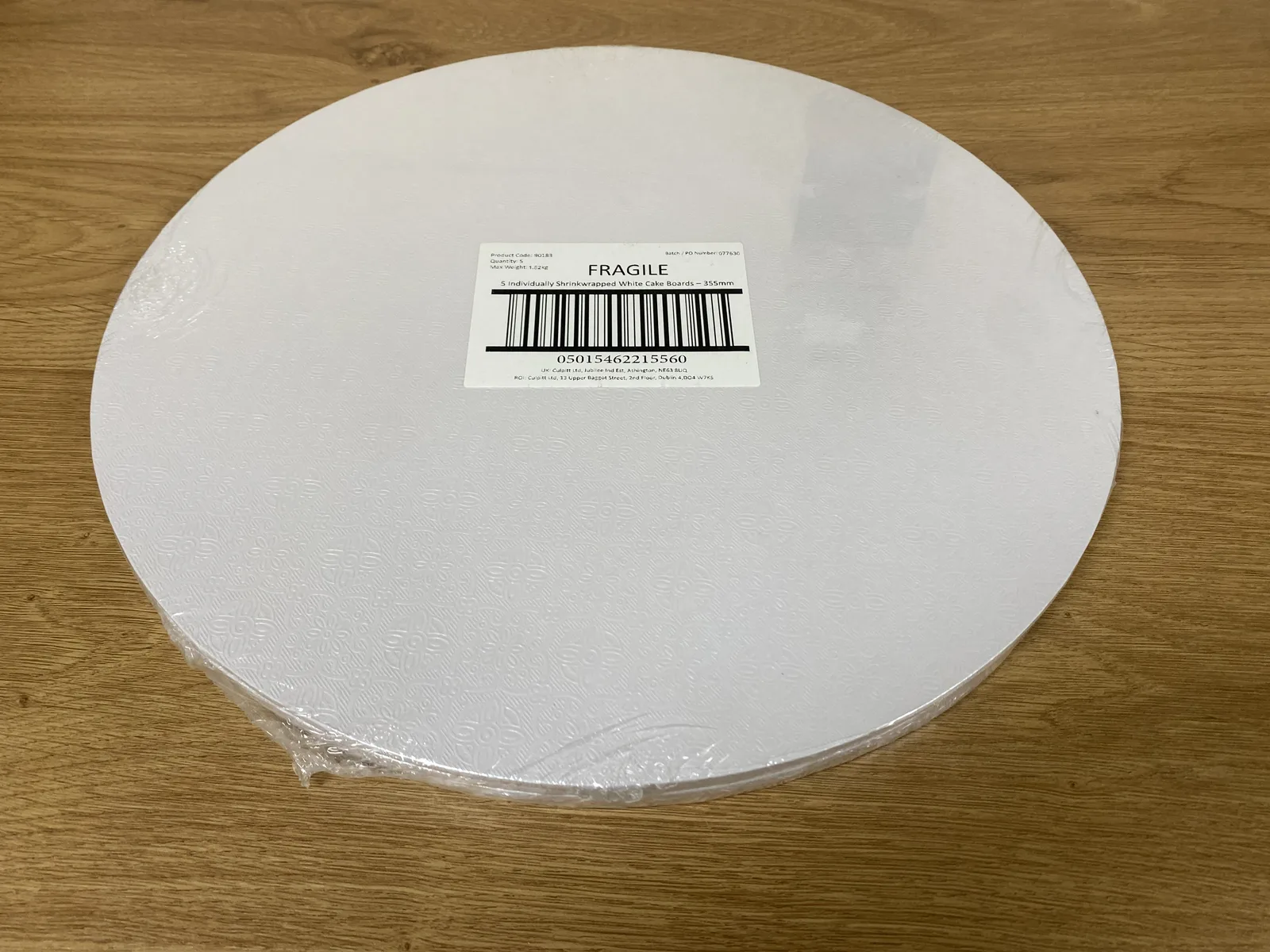 Five round white patterned 14-inch cake boards